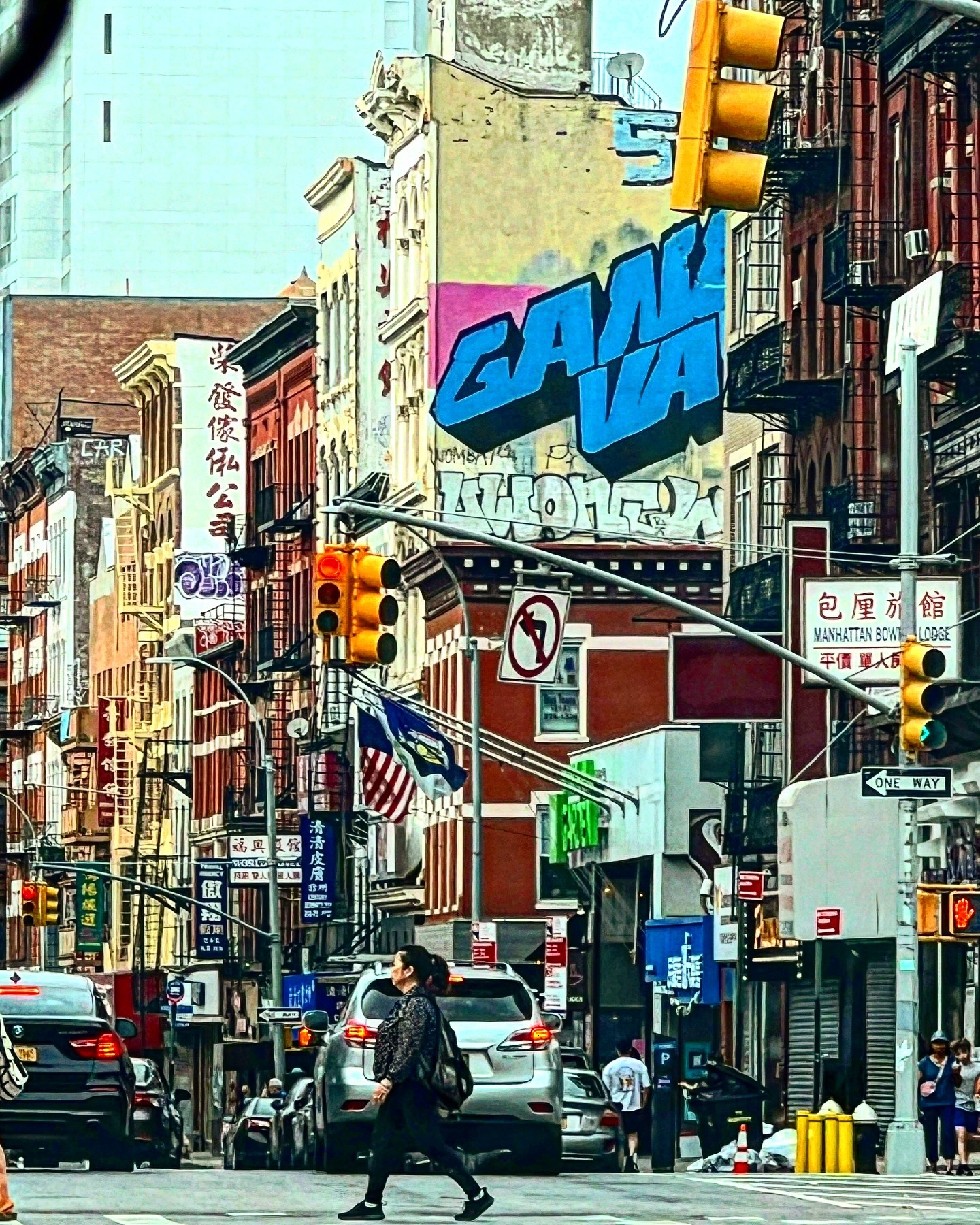 A colorful downtown Manhattan street scene with signs and fire escapes