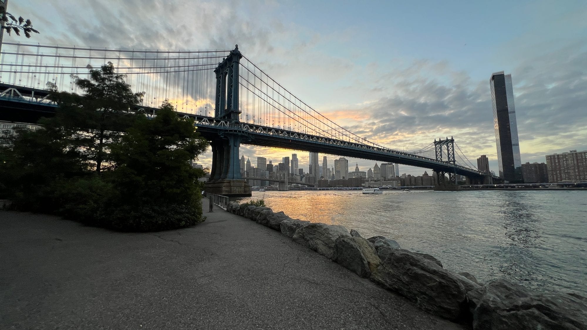 The Manhattan Bridge from the DUMBO lookout path at sunrise, with the Lower Manhattan skyline sitting neatly beneath its span.